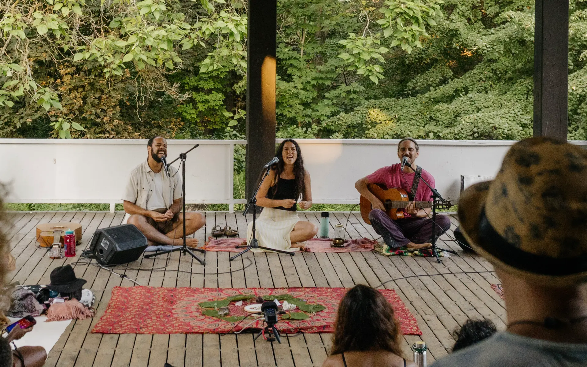 Musicians leading a song circle surrounded by trees